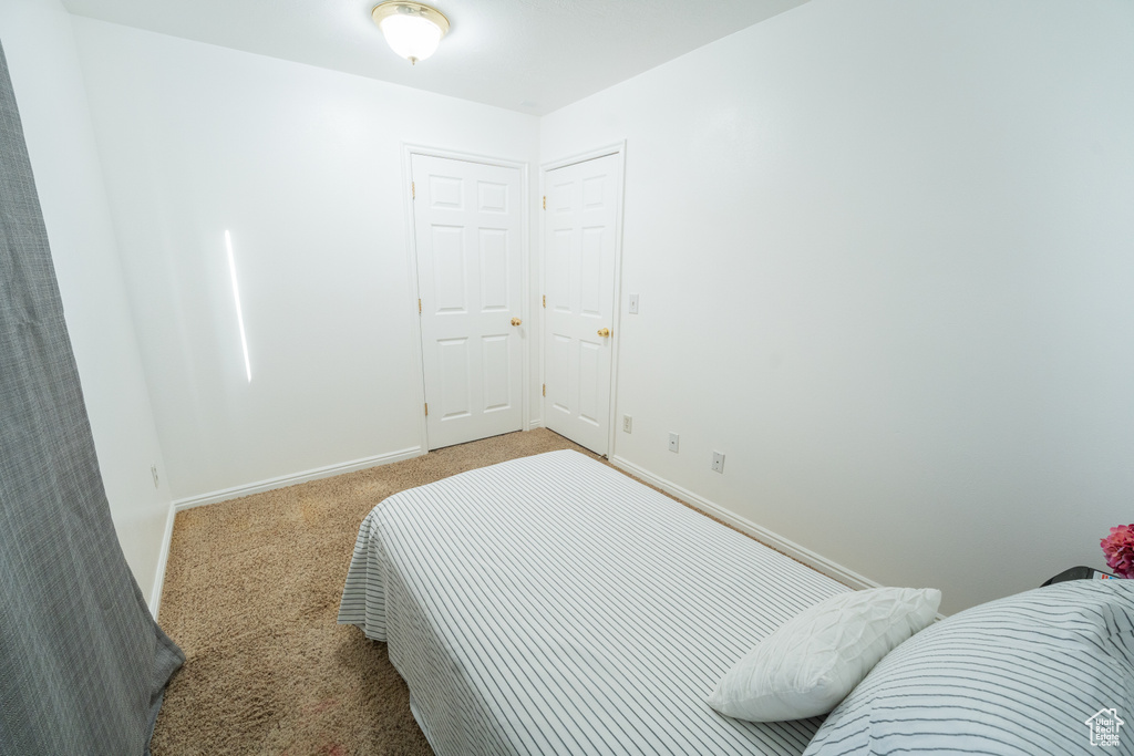 Bedroom featuring carpet and baseboards