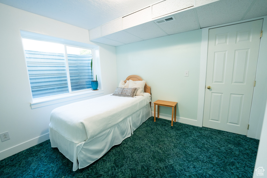 Bedroom featuring dark colored carpet and baseboards