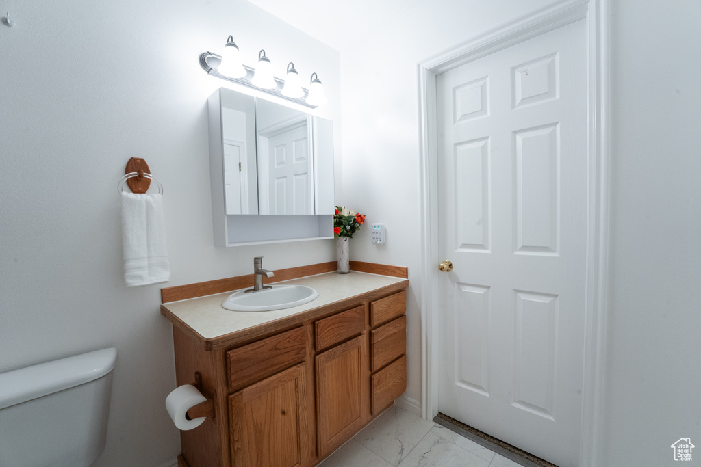 Bathroom with vanity and marble look tile flooring