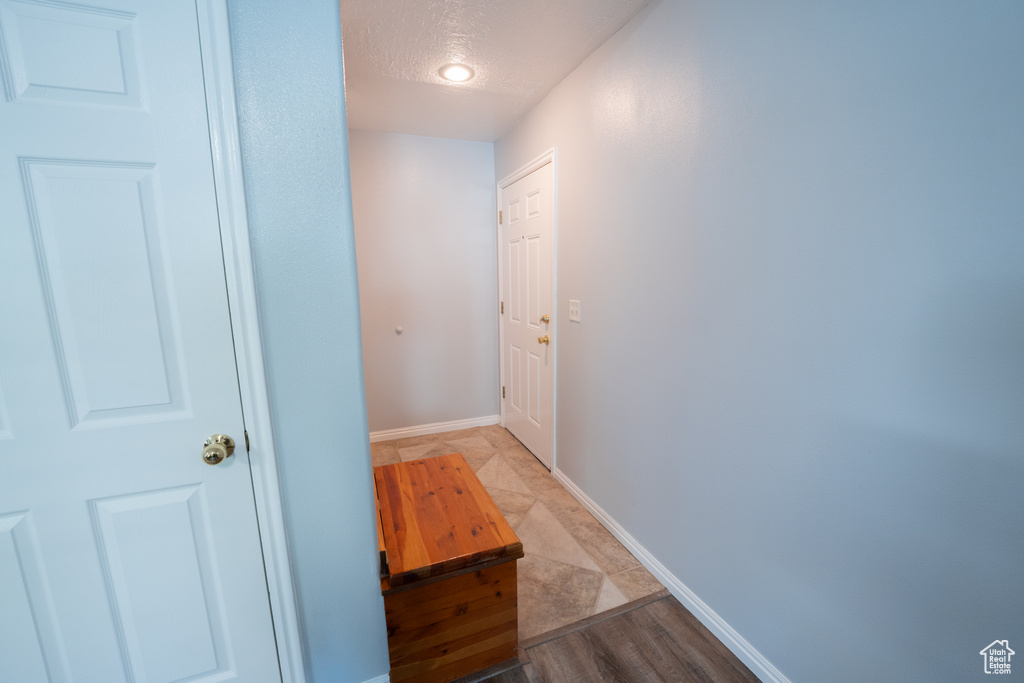 Corridor with baseboards and a textured ceiling