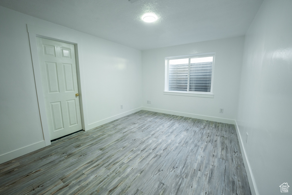 Unfurnished room with wood finished floors and baseboards