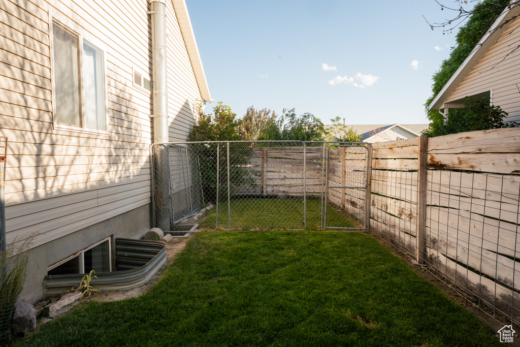 Fenced backyard featuring a gate