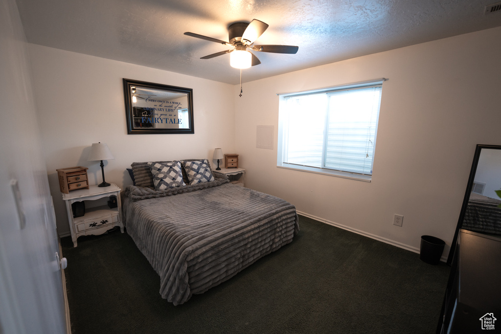 Bedroom with dark carpet and ceiling fan