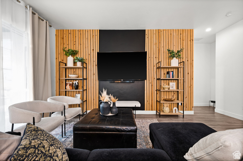 Living room featuring wood finished floors, built in features, and recessed lighting