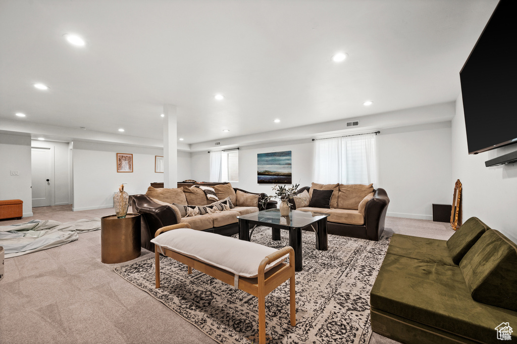 Living area with recessed lighting and light carpet