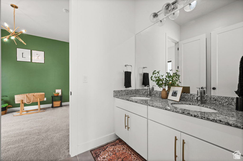 Full bathroom featuring double vanity and baseboards