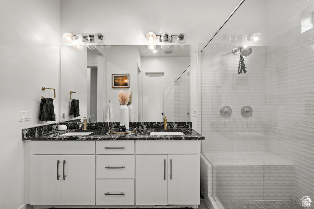 Full bathroom with double vanity and a shower stall