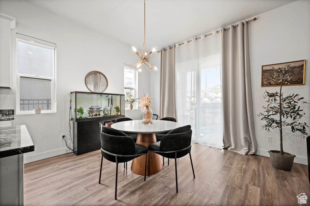 Dining area with wood finished floors and a chandelier