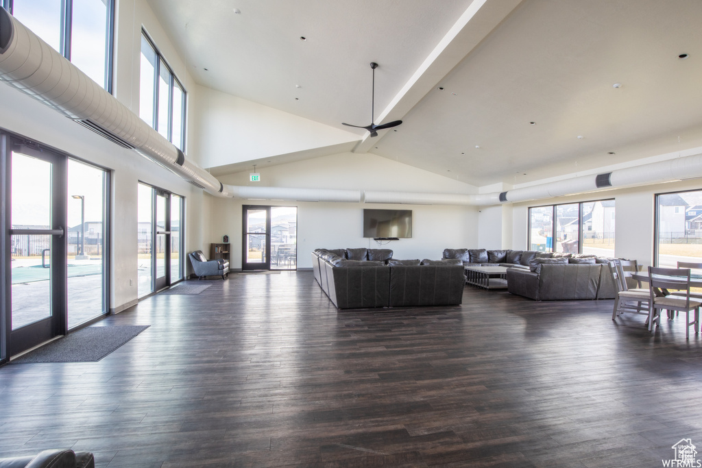 Living area featuring high vaulted ceiling, dark wood-type flooring, and ceiling fan