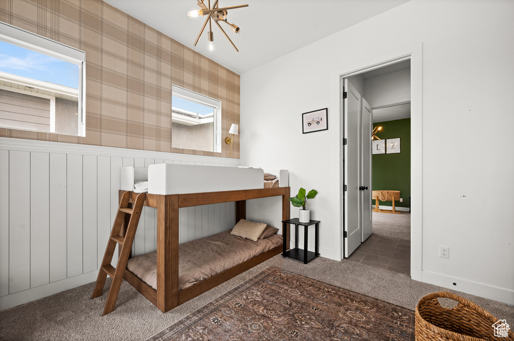 Bedroom featuring carpet flooring, a chandelier, and wainscoting