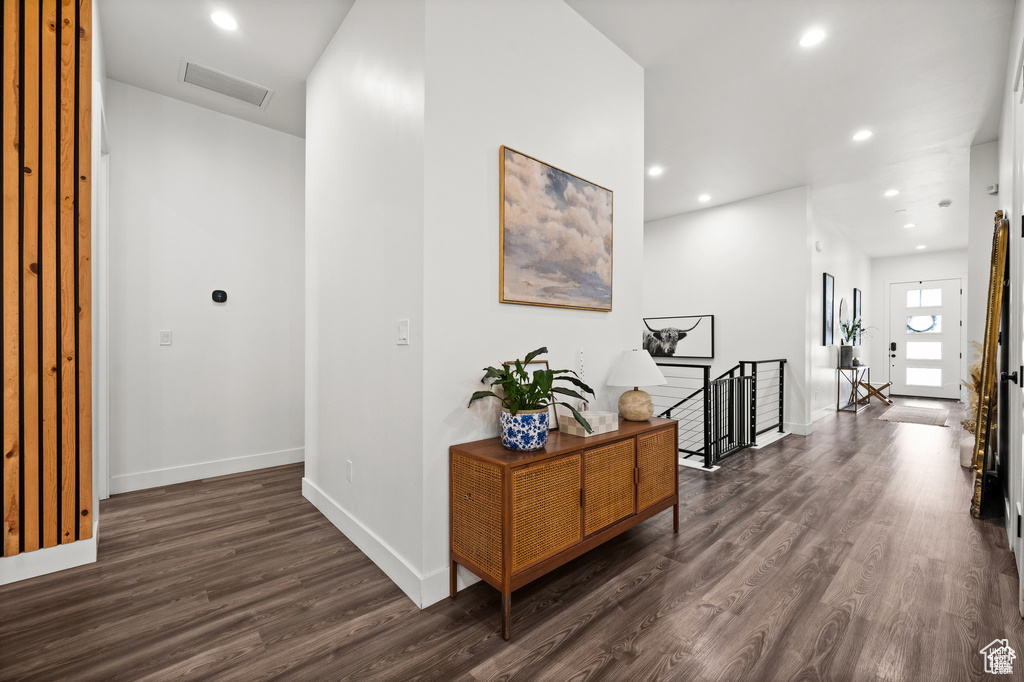 Hall featuring an upstairs landing, dark wood finished floors, and recessed lighting