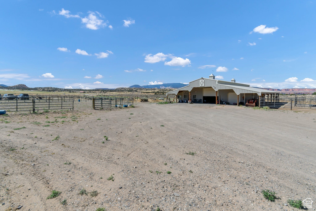 View of yard with an outdoor structure, a mountain view, a view of rural / pastoral area, a pole building, and a detached garage