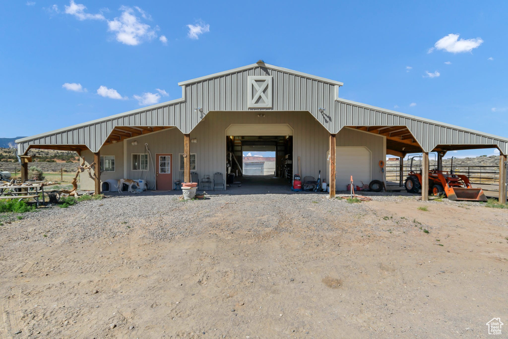 View of outdoor structure featuring dirt driveway