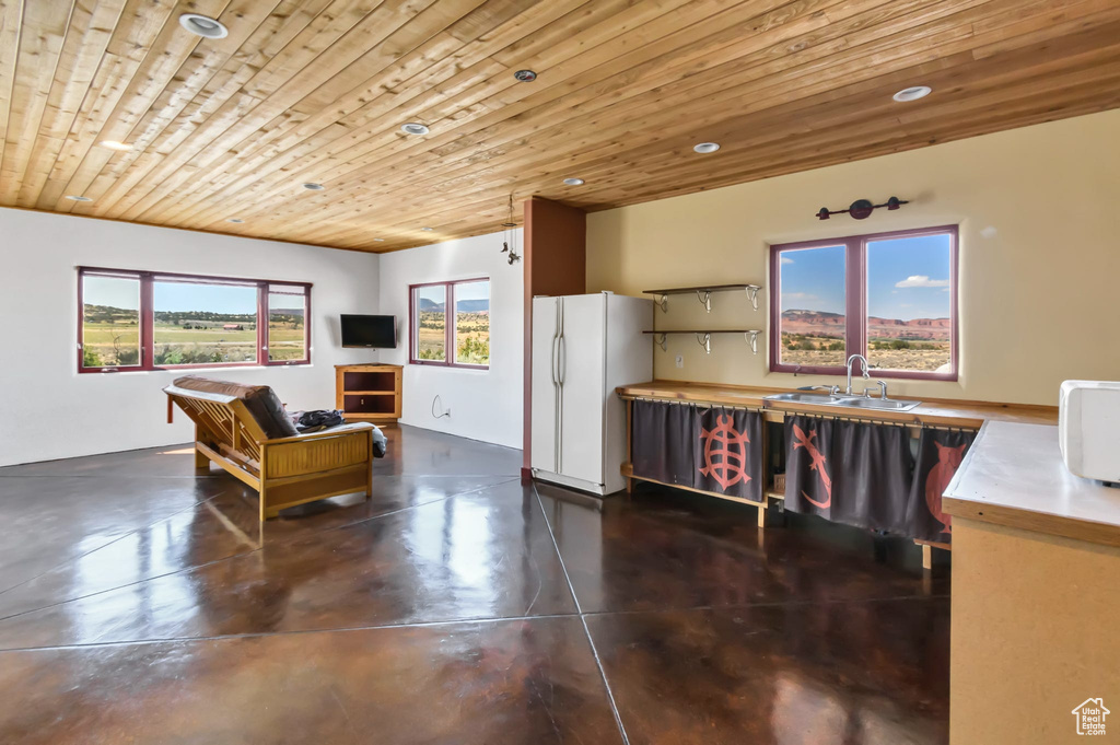 Living area featuring finished concrete floors, wood ceiling, and recessed lighting