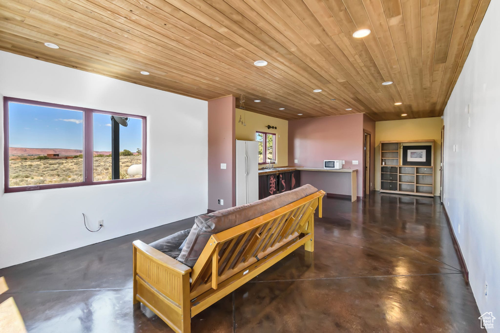 Living room featuring recessed lighting, finished concrete floors, and wood ceiling
