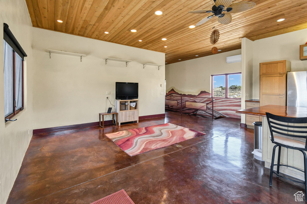 Living room with finished concrete floors, recessed lighting, wood ceiling, and ceiling fan