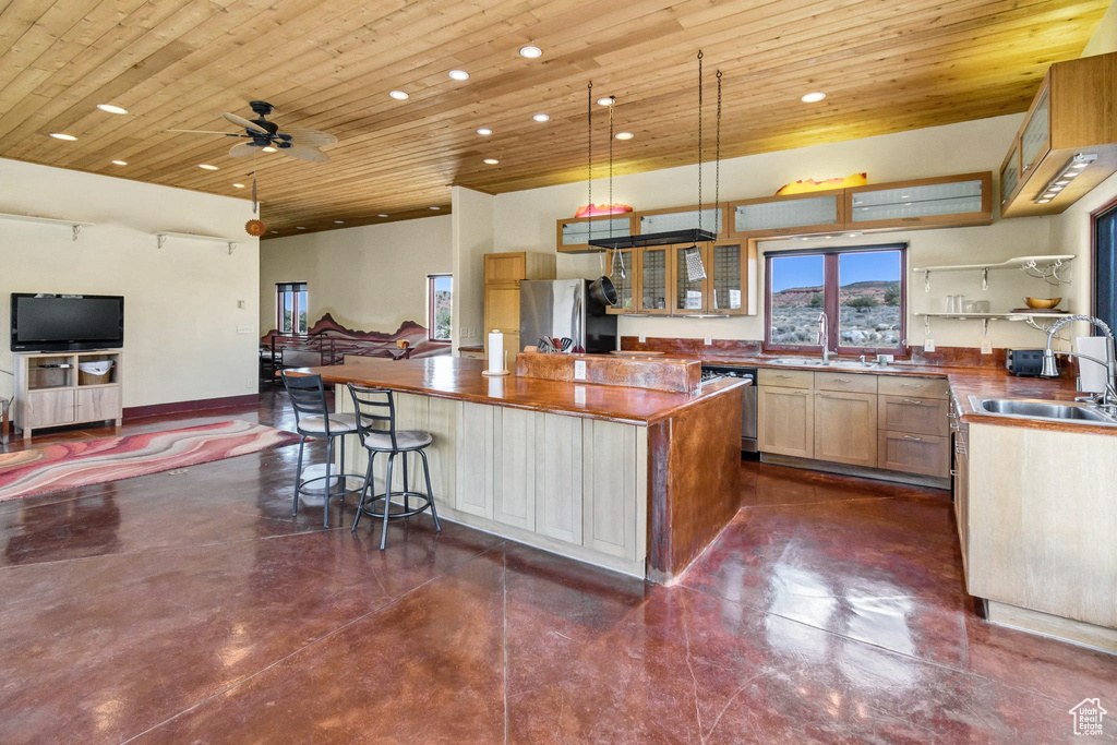 Kitchen with stainless steel appliances, wood ceiling, a center island, finished concrete flooring, and recessed lighting