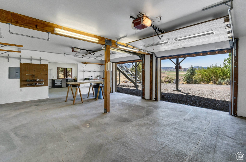 Garage featuring a garage door opener and electric panel