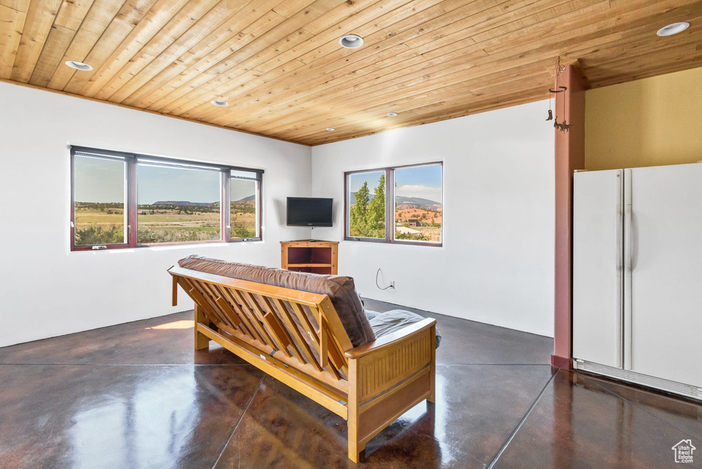 Living area featuring wood ceiling, concrete flooring, and recessed lighting