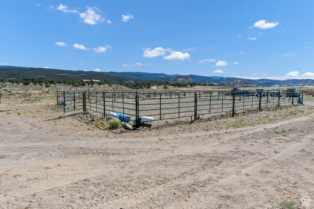 View of yard featuring a view of countryside, an enclosed horse arena, and a mountain view