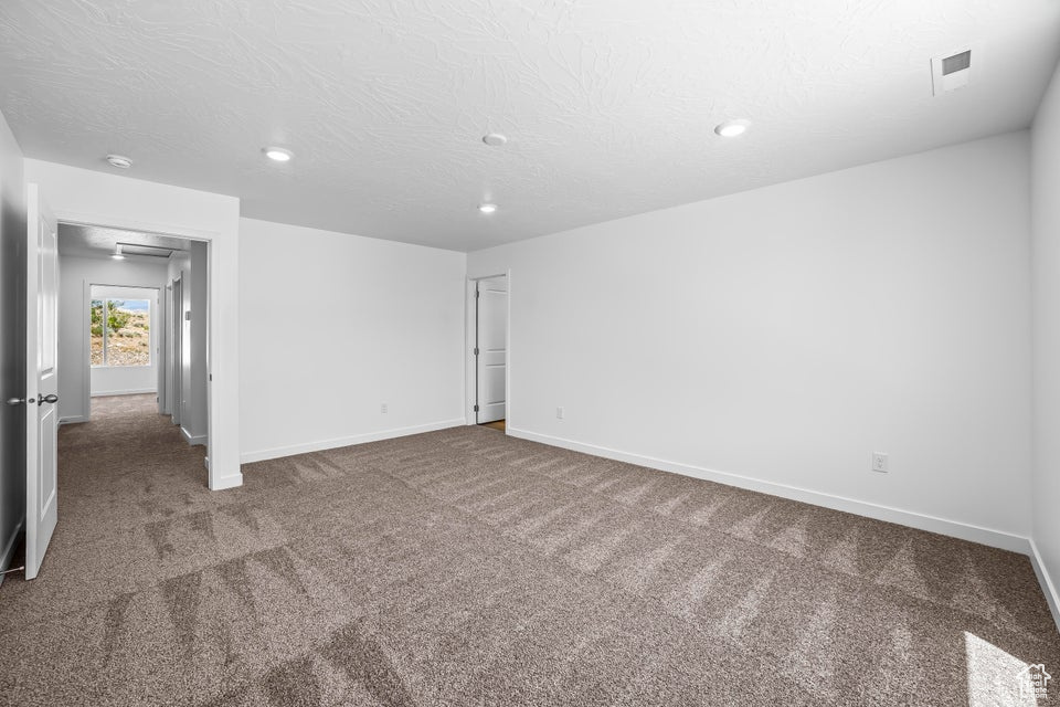 Spare room with carpet, recessed lighting, a textured ceiling, and a smoke detector