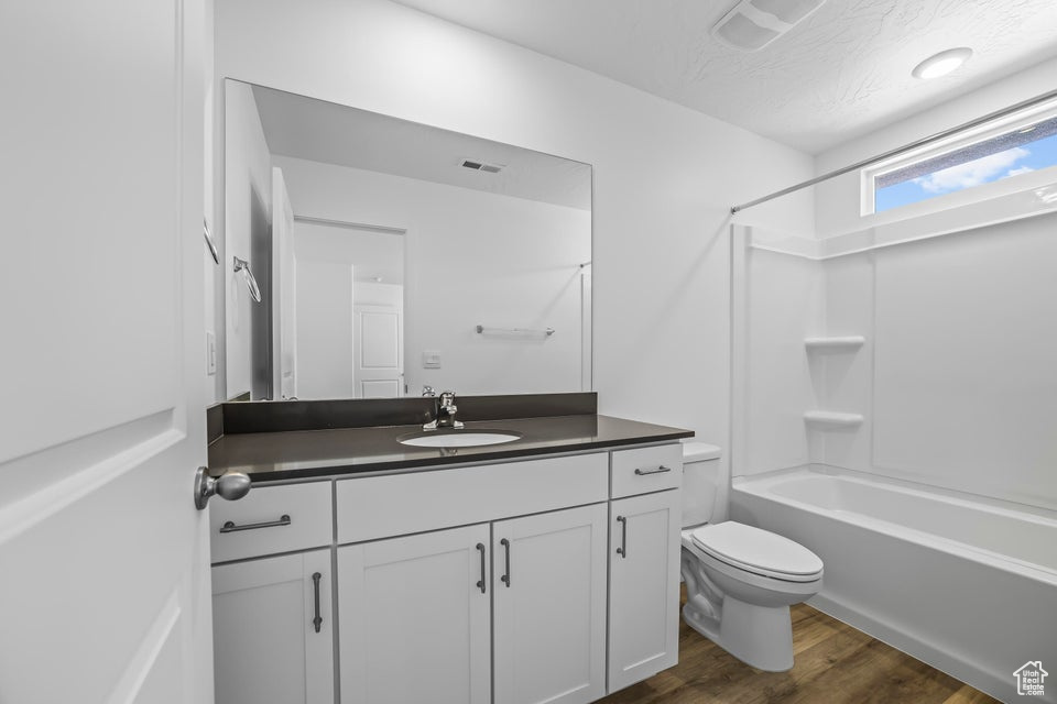 Full bathroom with vanity, bathtub / shower combination, and wood finished floors
