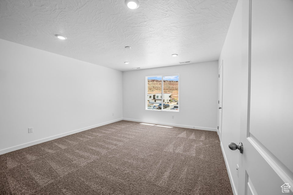 Carpeted spare room featuring recessed lighting and a textured ceiling