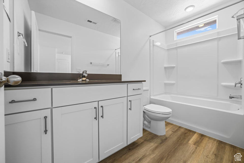 Full bathroom featuring vanity, shower / bathtub combination, and wood finished floors