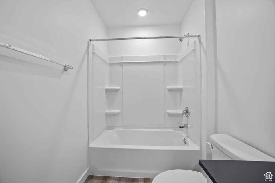 Bathroom featuring wood finished floors, bathing tub / shower combination, and vanity