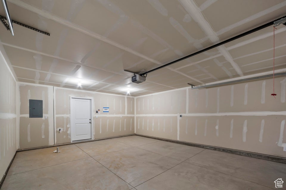 Garage featuring electric panel and a garage door opener