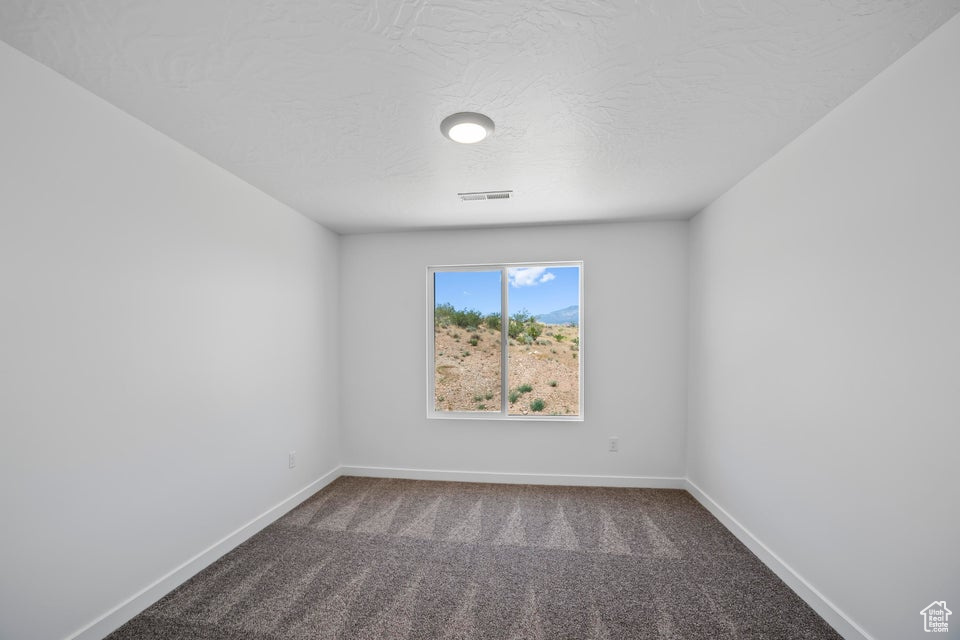 Carpeted empty room featuring baseboards