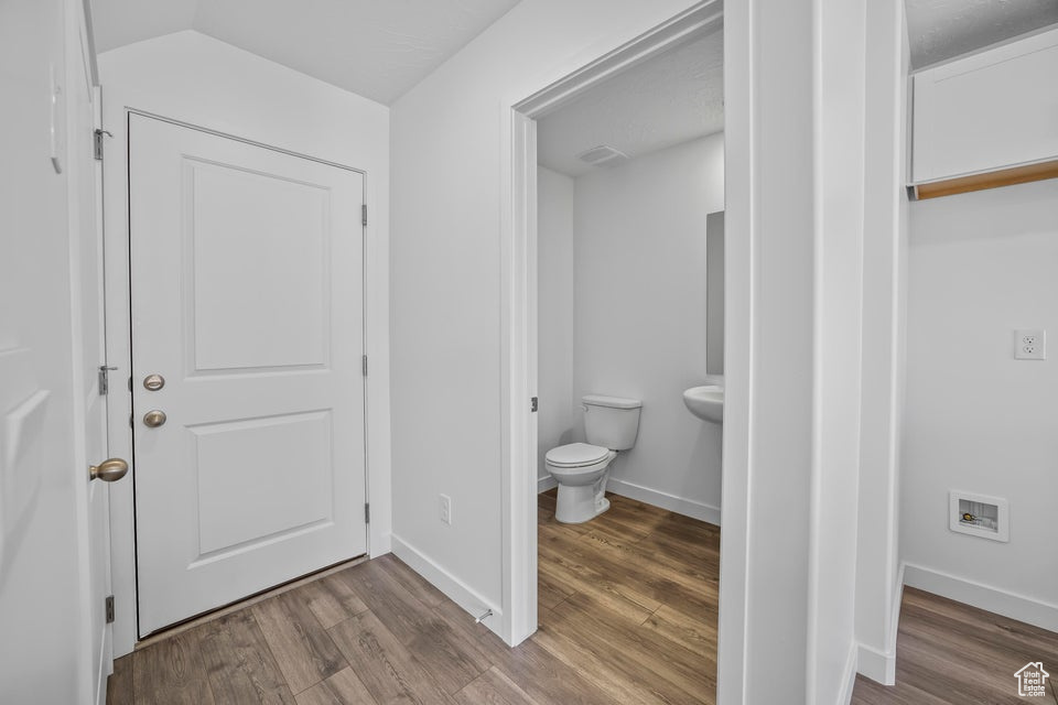 Bathroom with wood finished floors and vaulted ceiling