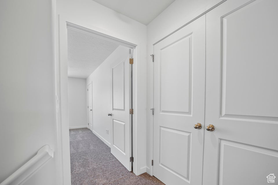 Hallway featuring carpet and baseboards