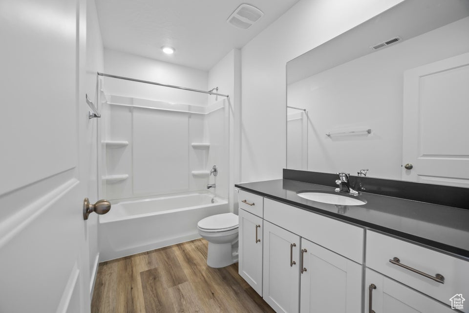 Full bathroom featuring vanity, wood finished floors, and shower / bathtub combination