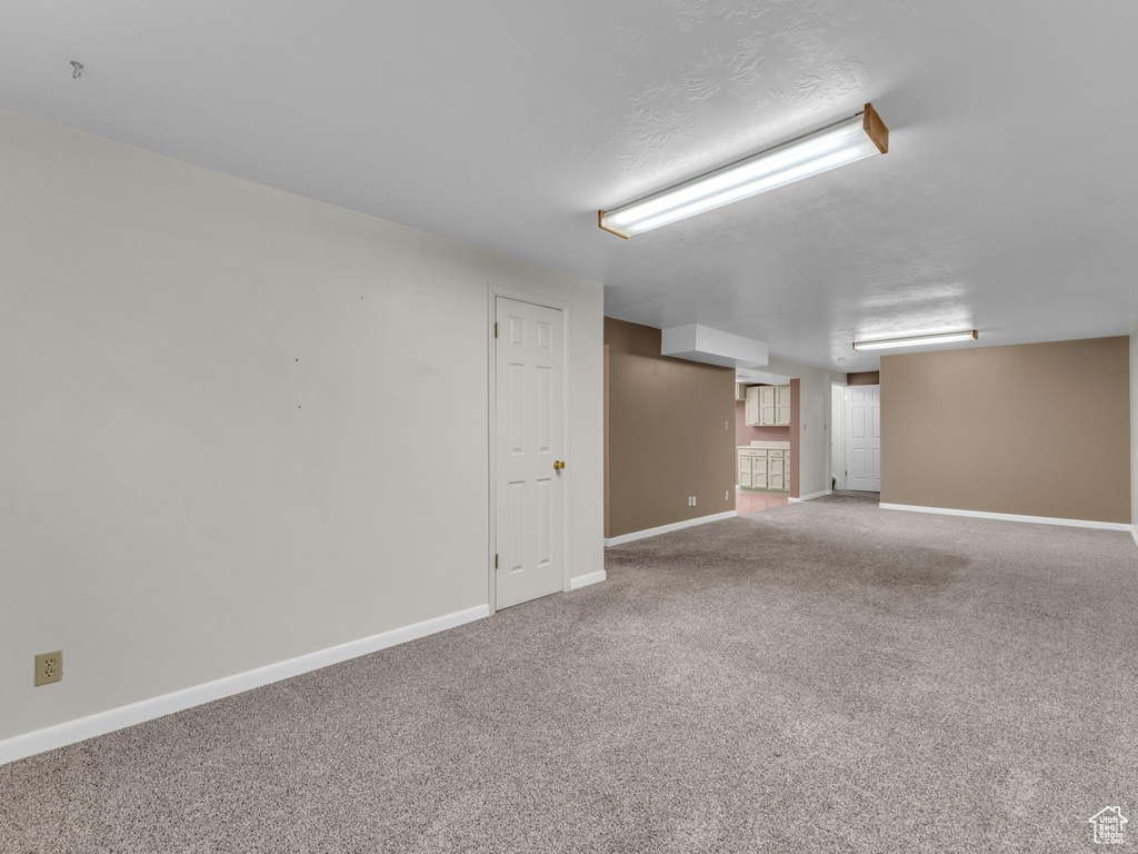 Below grade area featuring baseboards and carpet