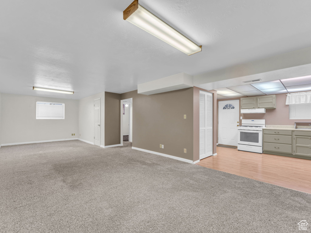 Unfurnished living room with light carpet and baseboards