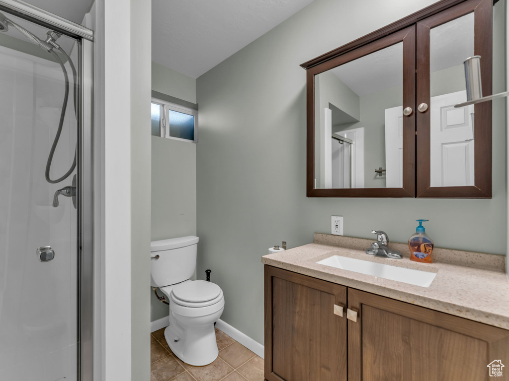 Full bathroom featuring vanity, tile patterned floors, and a stall shower