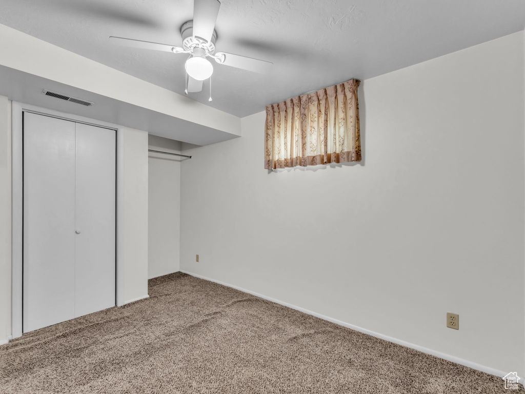 Unfurnished bedroom with carpet flooring and a ceiling fan