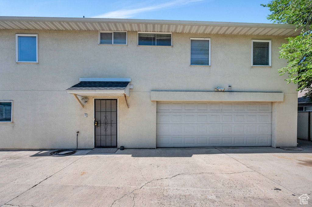 View of front of house featuring stucco siding, concrete driveway, and a garage