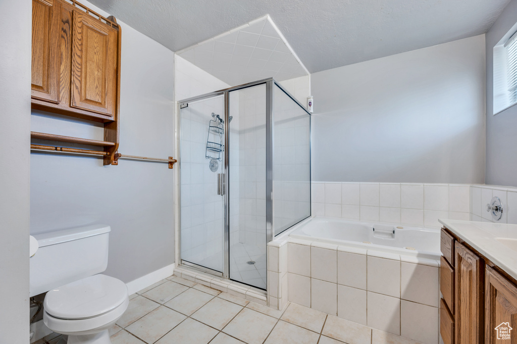 Bathroom with a garden tub, a shower stall, tile patterned floors, and vanity