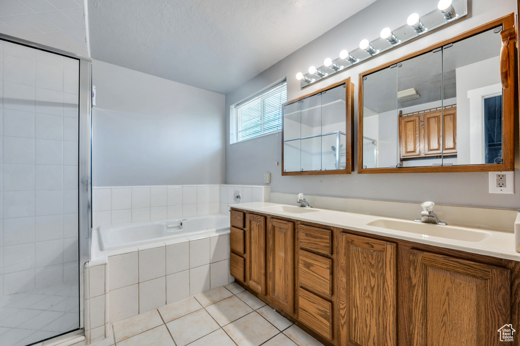 Bathroom with double vanity, a stall shower, a bath, and tile patterned floors