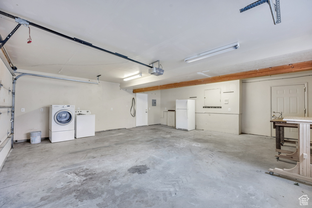 Garage featuring freestanding refrigerator and washer and dryer