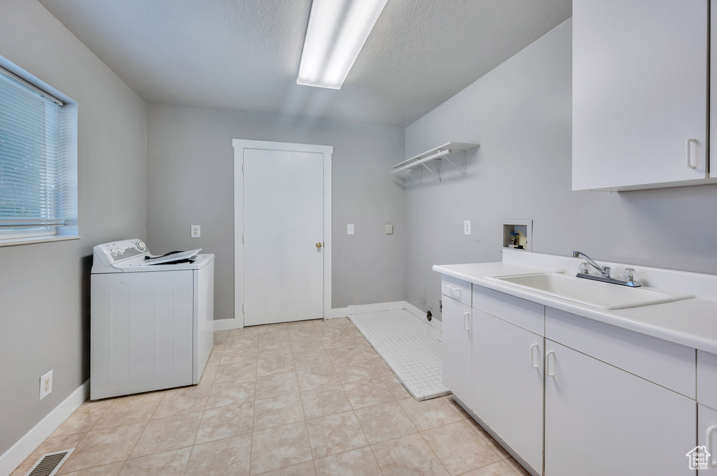 Laundry room featuring cabinet space, washer hookup, and light tile patterned flooring