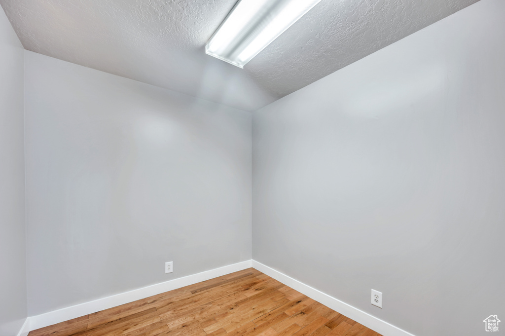 Unfurnished room featuring light wood-type flooring and a textured ceiling