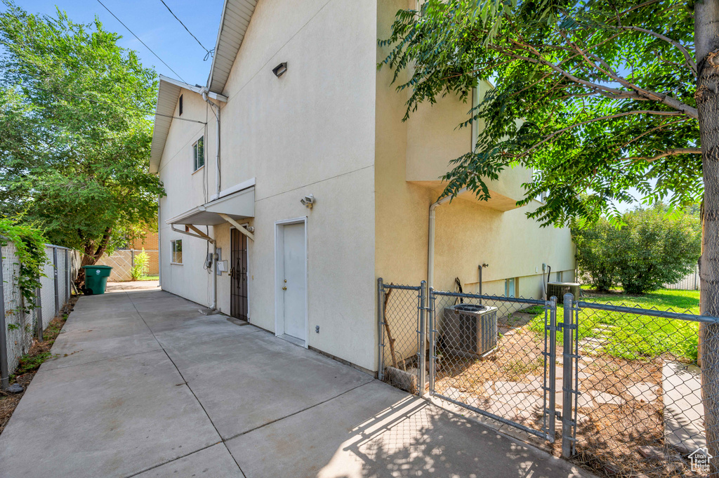 View of side of property featuring a gate, stucco siding, and a patio area