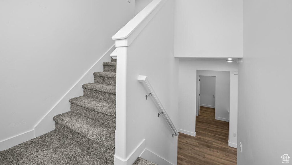 Stairway with wood finished floors and baseboards