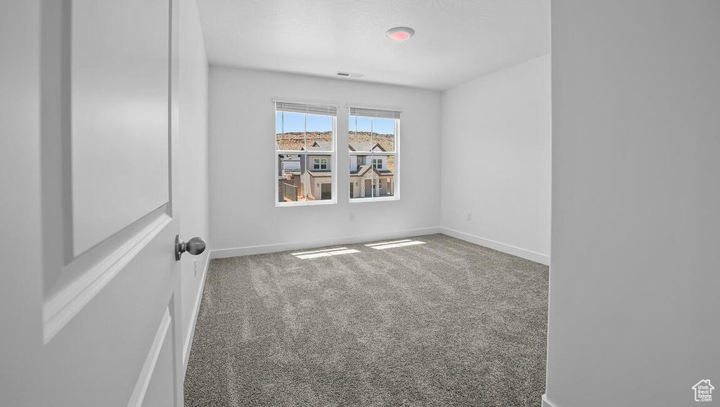 Spare room featuring carpet floors and baseboards