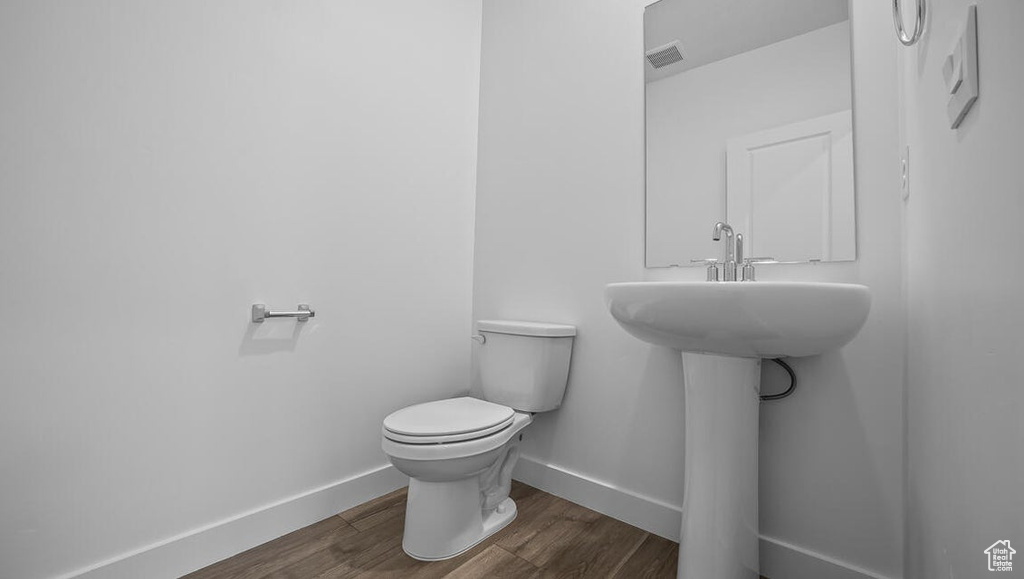Half bathroom featuring baseboards and wood finished floors