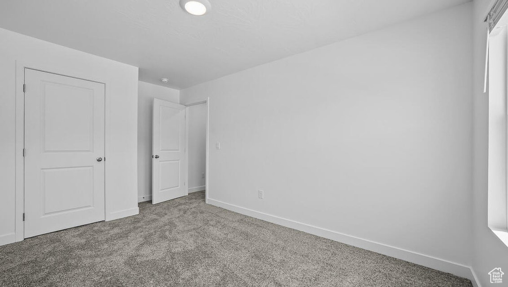 Unfurnished bedroom featuring carpet flooring and baseboards
