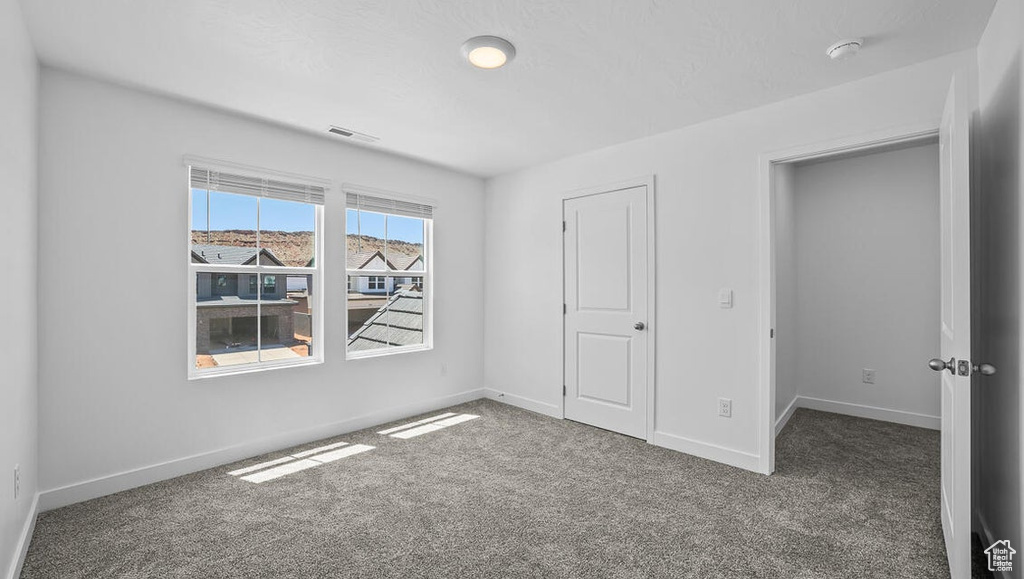 Unfurnished bedroom featuring carpet floors and baseboards